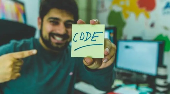 développeur avec un post-it où il est écrit CODE